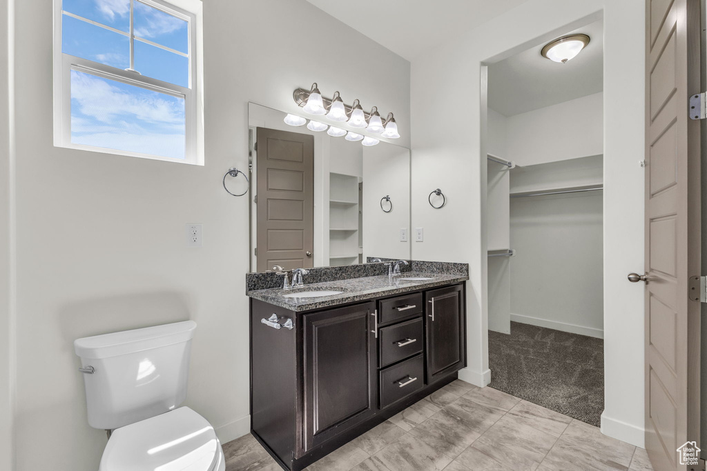Bathroom with double vanity and a spacious closet