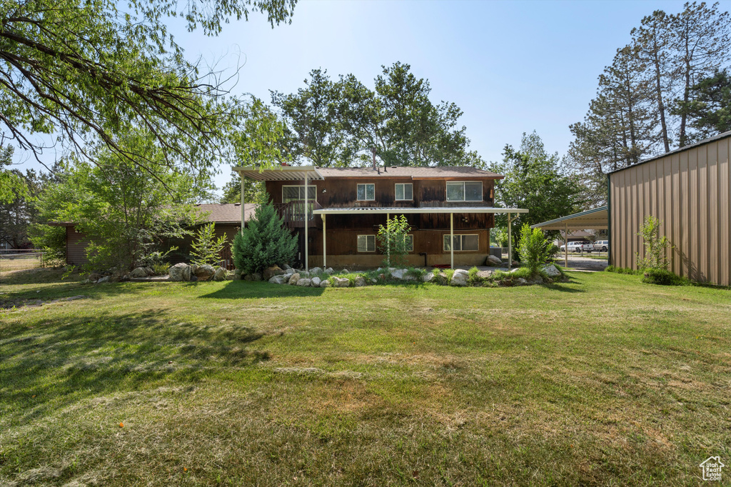 Back of property with a lawn