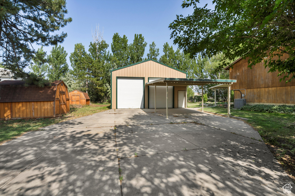 Garage featuring a detached garage and cooling unit