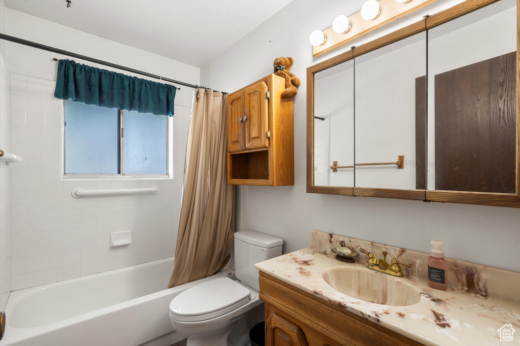 Bathroom featuring vanity, toilet, and shower / tub combo