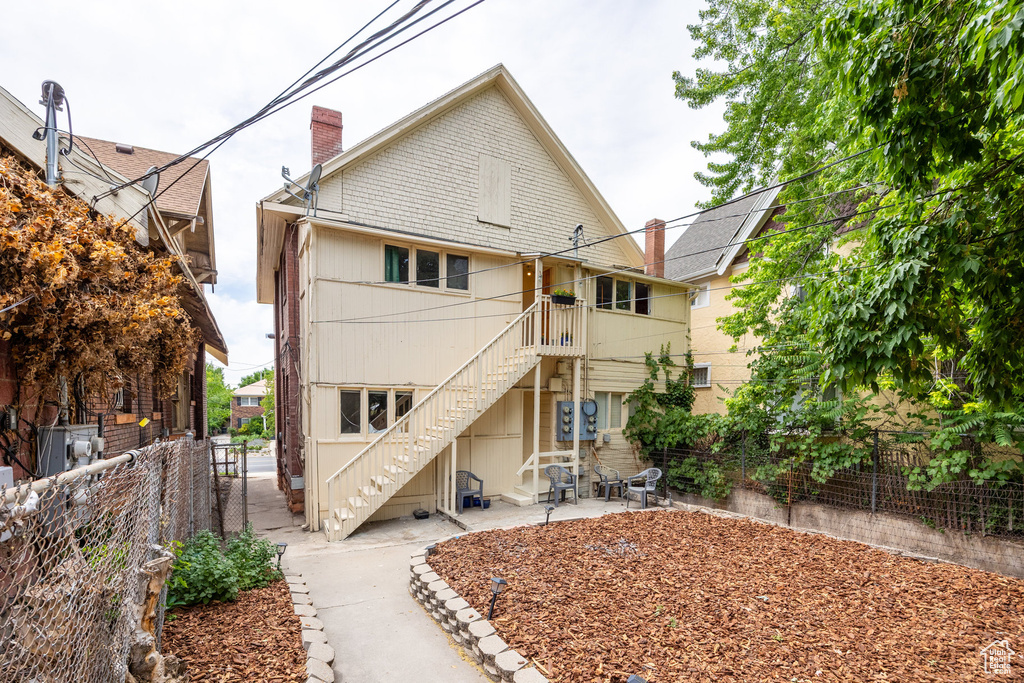 Rear view of property with stairway, a chimney, and a patio