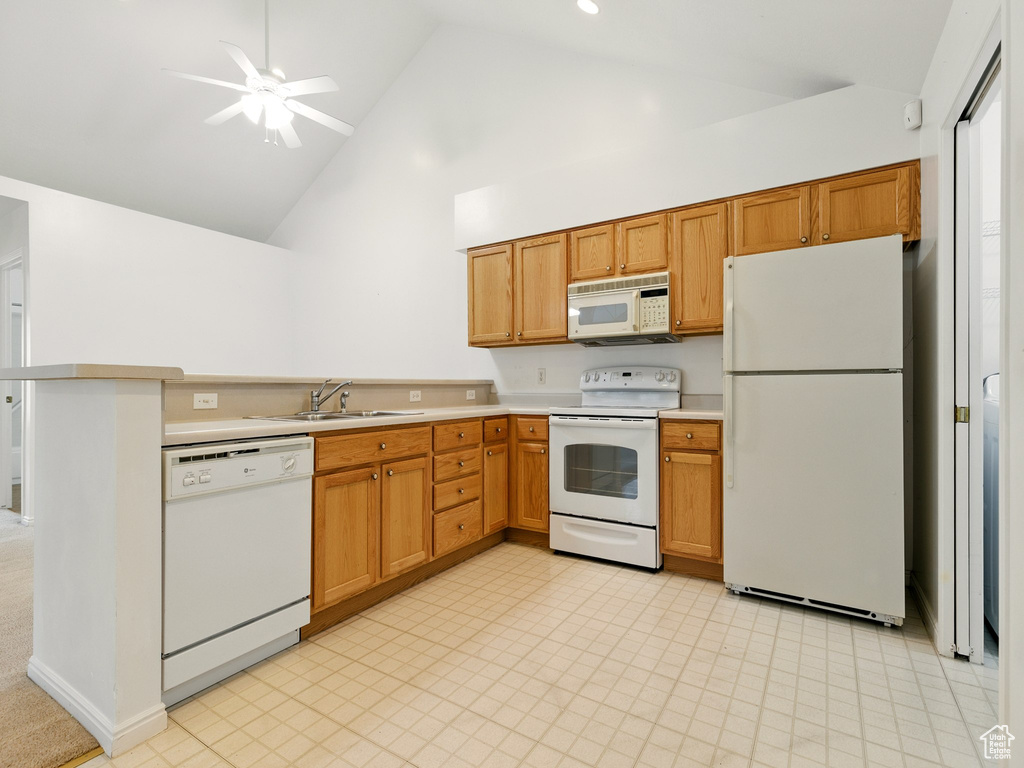 Kitchen with white appliances, high vaulted ceiling, light countertops, a peninsula, and ceiling fan