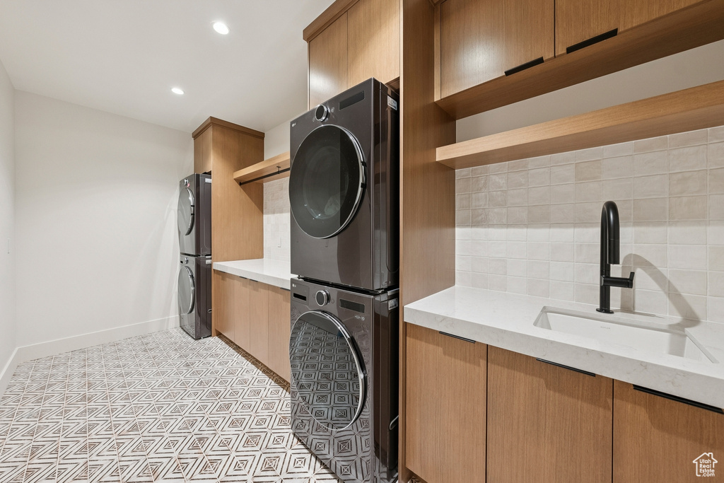Washroom with stacked washer and clothes dryer and recessed lighting