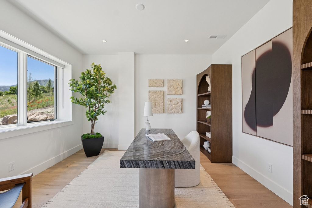 Office area with light wood finished floors and recessed lighting