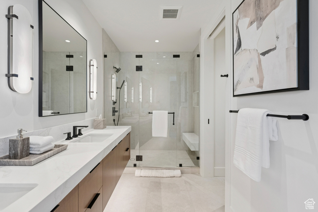 Bathroom with double vanity, a shower stall, recessed lighting, and tile patterned floors