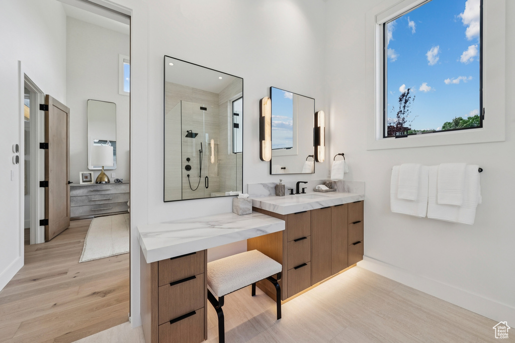 Bathroom with wood finished floors, a stall shower, vanity, and recessed lighting