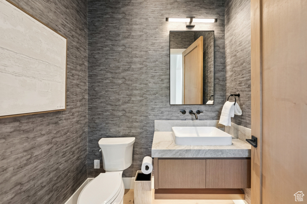 Half bathroom featuring vanity and toilet