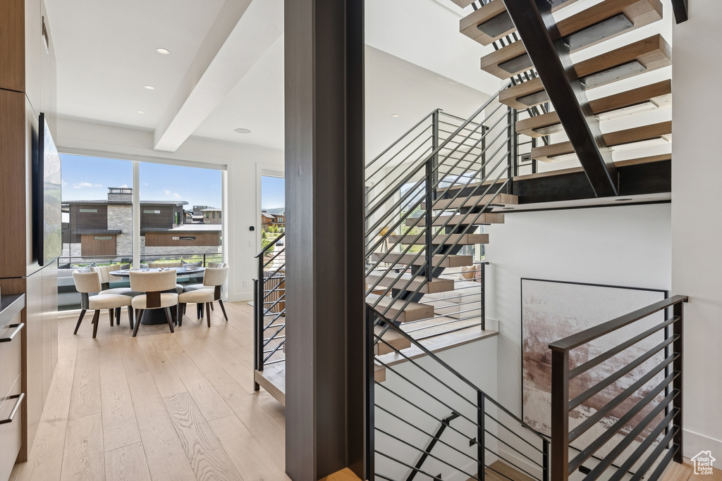 Stairs featuring hardwood / wood-style flooring, beam ceiling, and recessed lighting