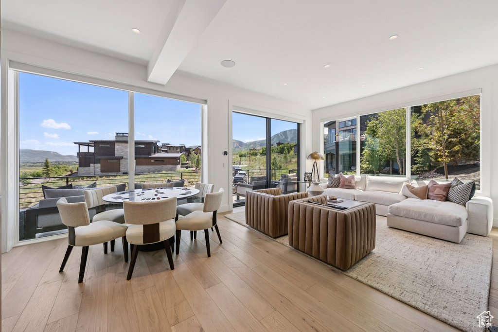 Living area featuring a mountain view, light wood finished floors, and beamed ceiling