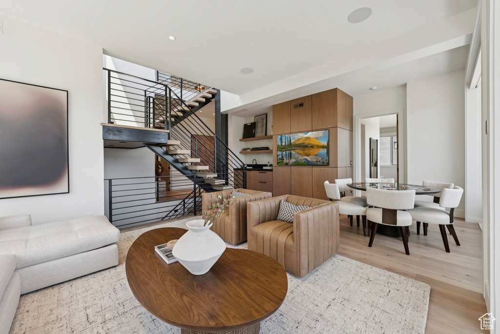 Living area featuring light wood-style flooring, stairway, and recessed lighting