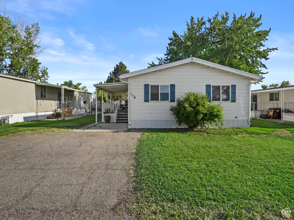 Manufactured / mobile home featuring a front yard and asphalt driveway