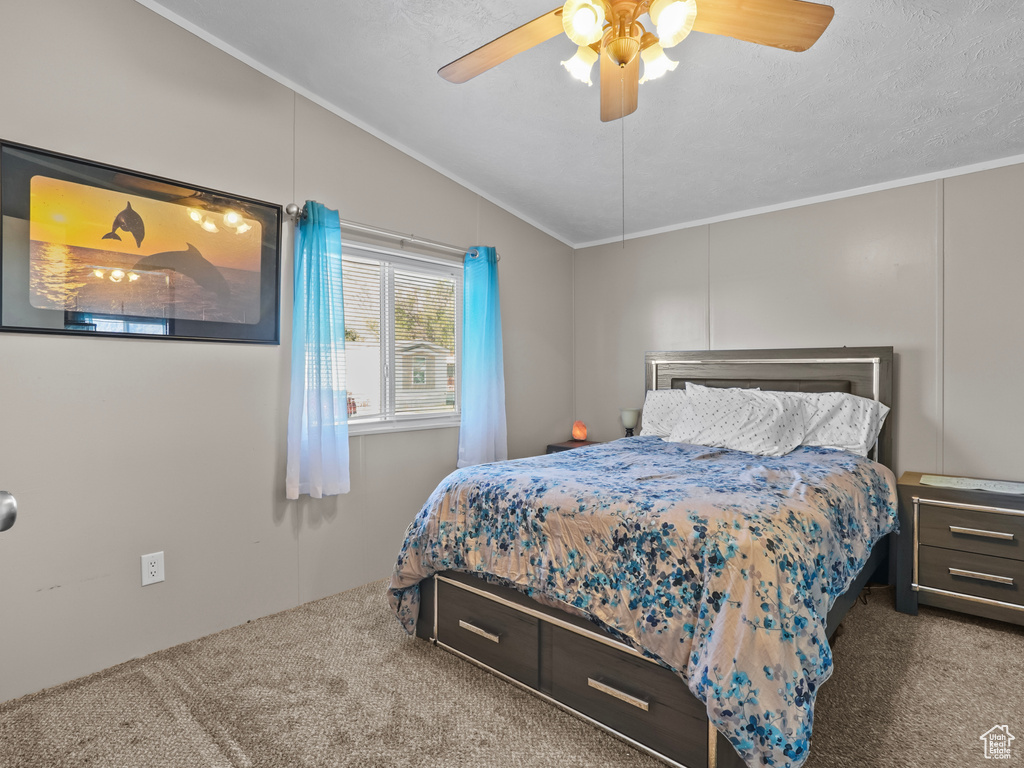 Bedroom with carpet, crown molding, lofted ceiling, and a ceiling fan
