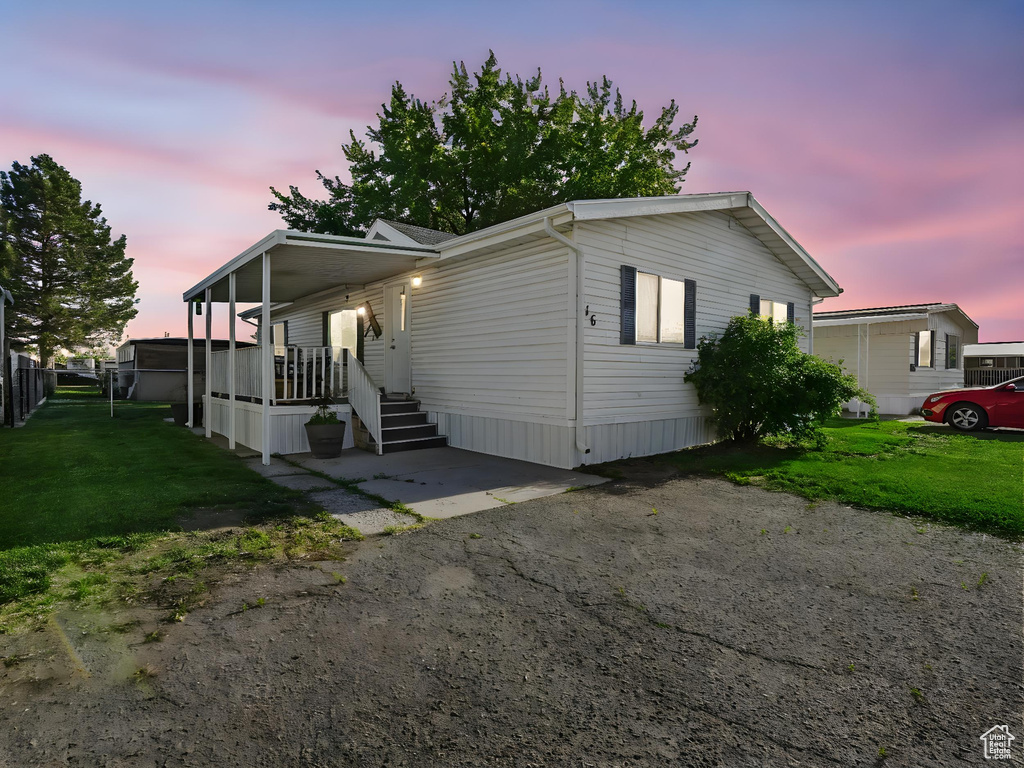 Manufactured / mobile home featuring a front yard and covered porch