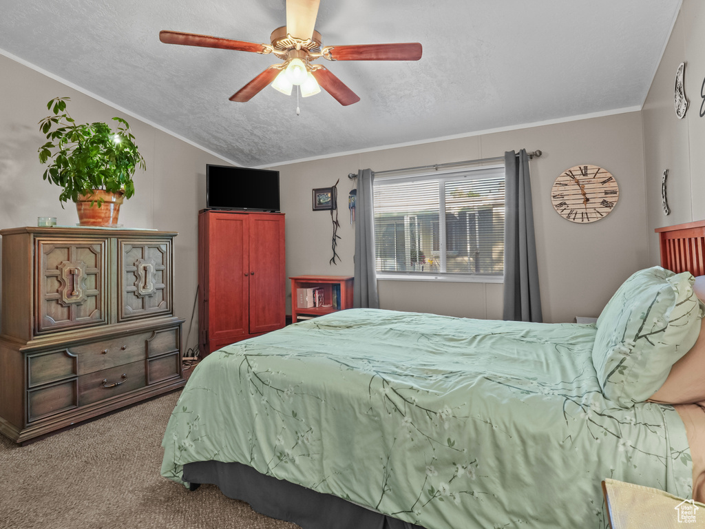 Bedroom with carpet, ceiling fan, crown molding, and vaulted ceiling
