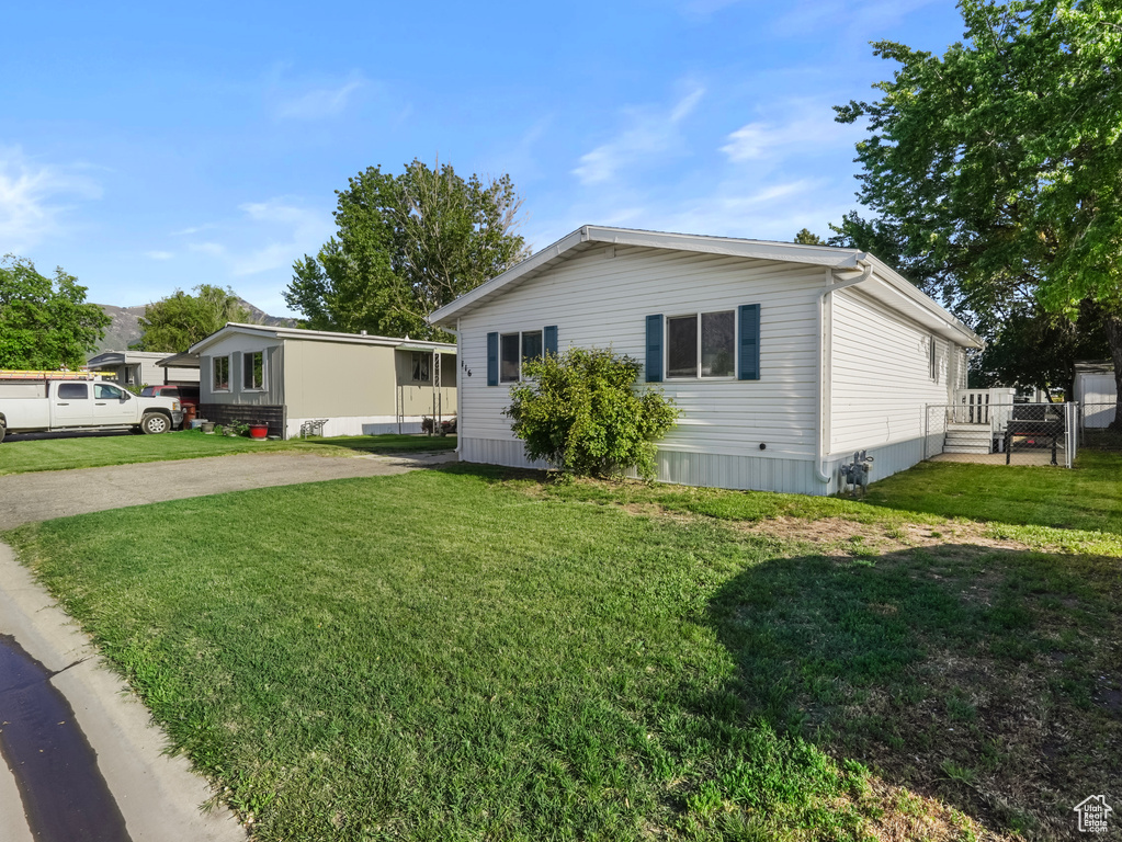 Manufactured / mobile home with a gate, a front lawn, and concrete driveway