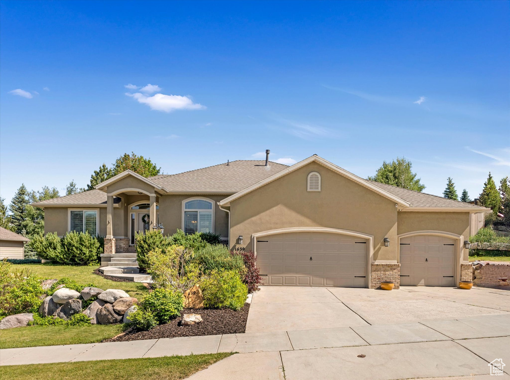 Ranch-style house with a garage, stucco siding, and concrete driveway