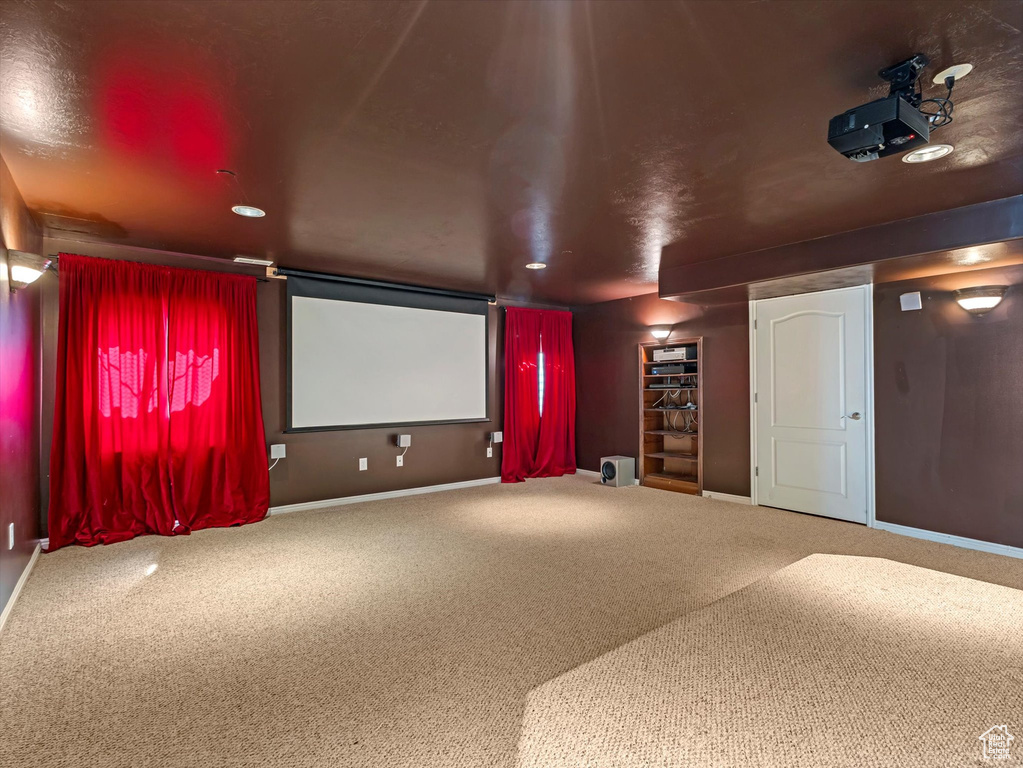 Carpeted cinema room featuring baseboards