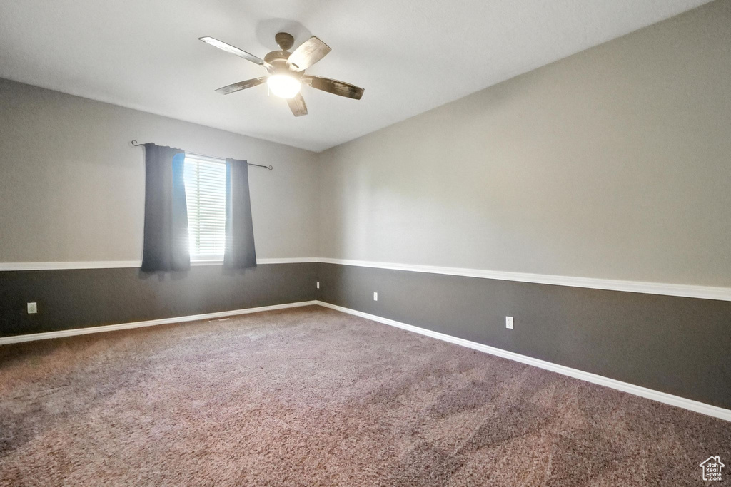 Spare room featuring ceiling fan and carpet floors