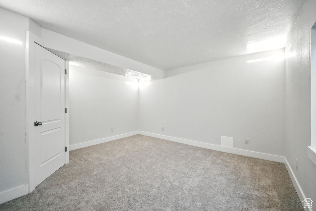 Finished basement featuring light carpet and baseboards