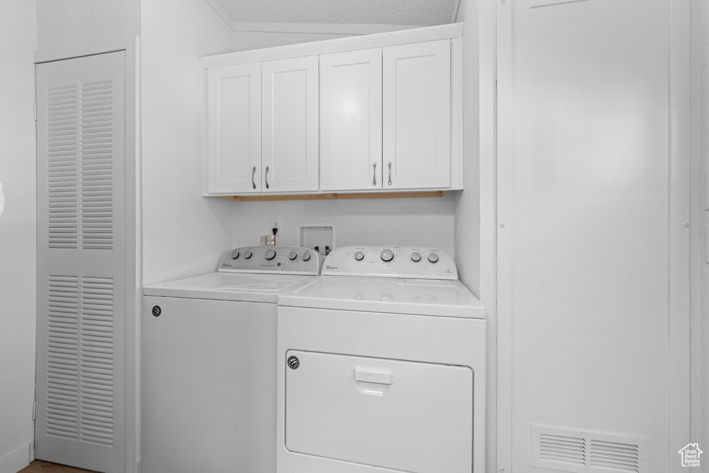 Laundry room featuring washing machine and clothes dryer and cabinet space