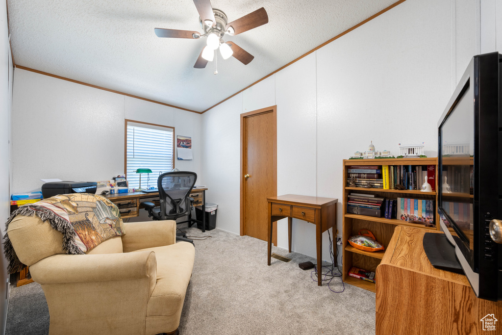Office with vaulted ceiling, crown molding, carpet flooring, a textured ceiling, and a ceiling fan