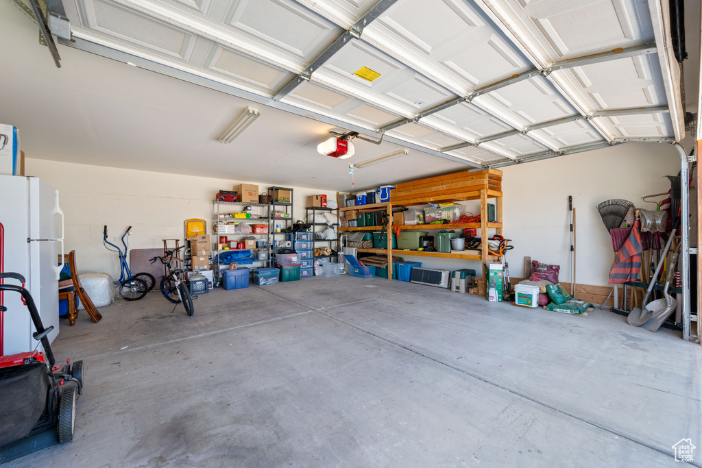 Garage with freestanding refrigerator and a garage door opener