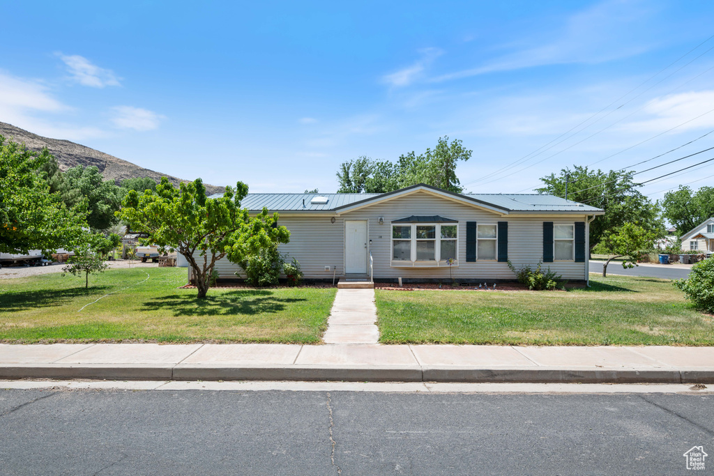 View of front facade with a front lawn and a metal roof