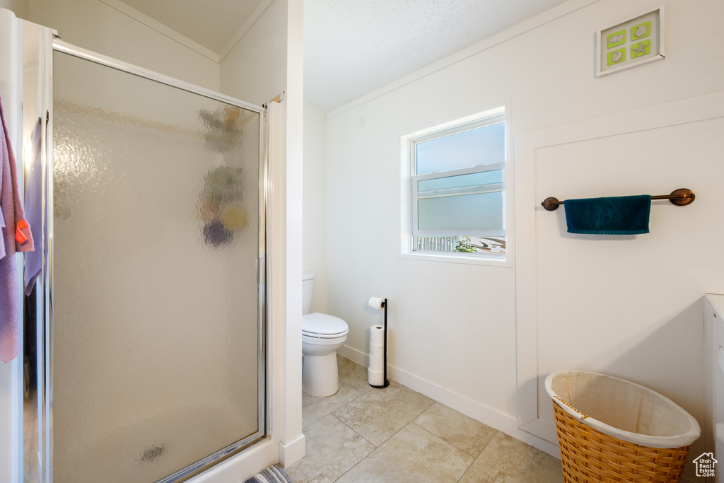 Bathroom with a shower stall and tile patterned floors