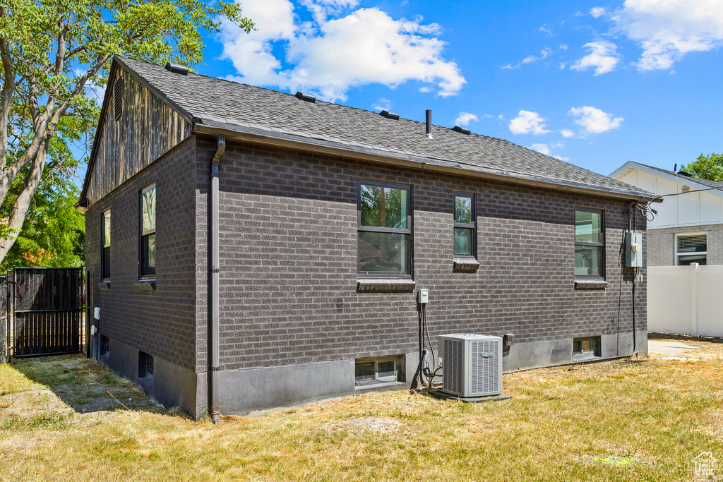View of side of property featuring brick siding and a shingled roof