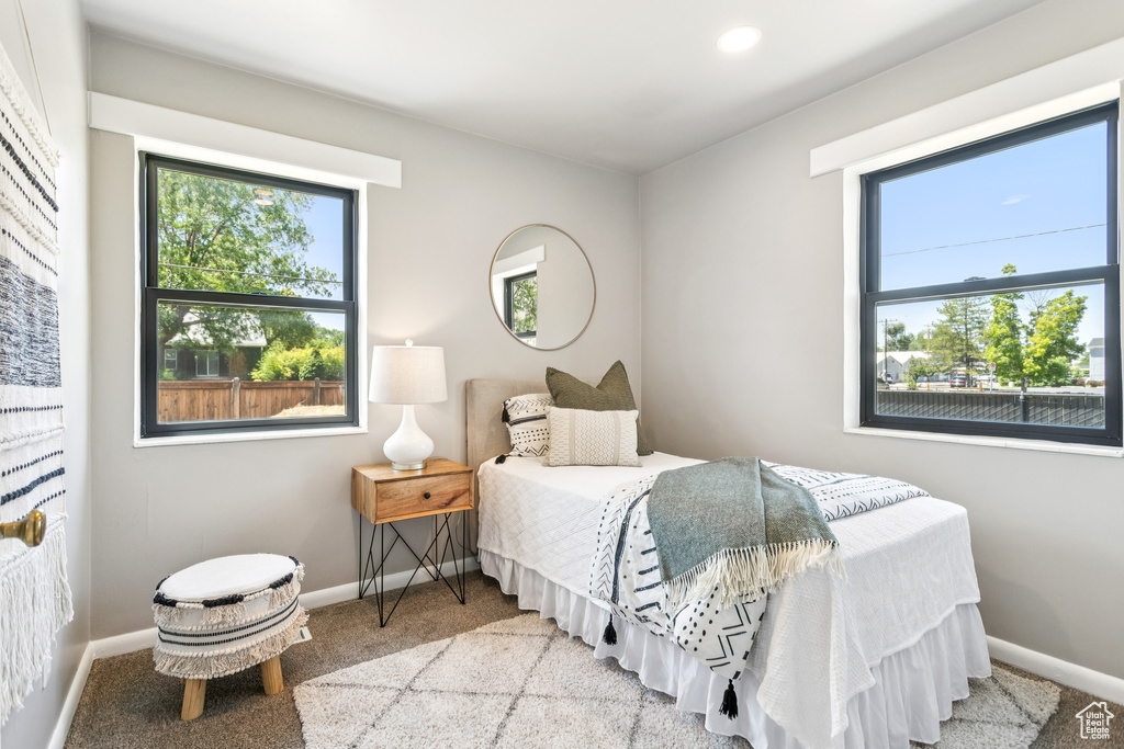 Carpeted bedroom featuring multiple windows and recessed lighting