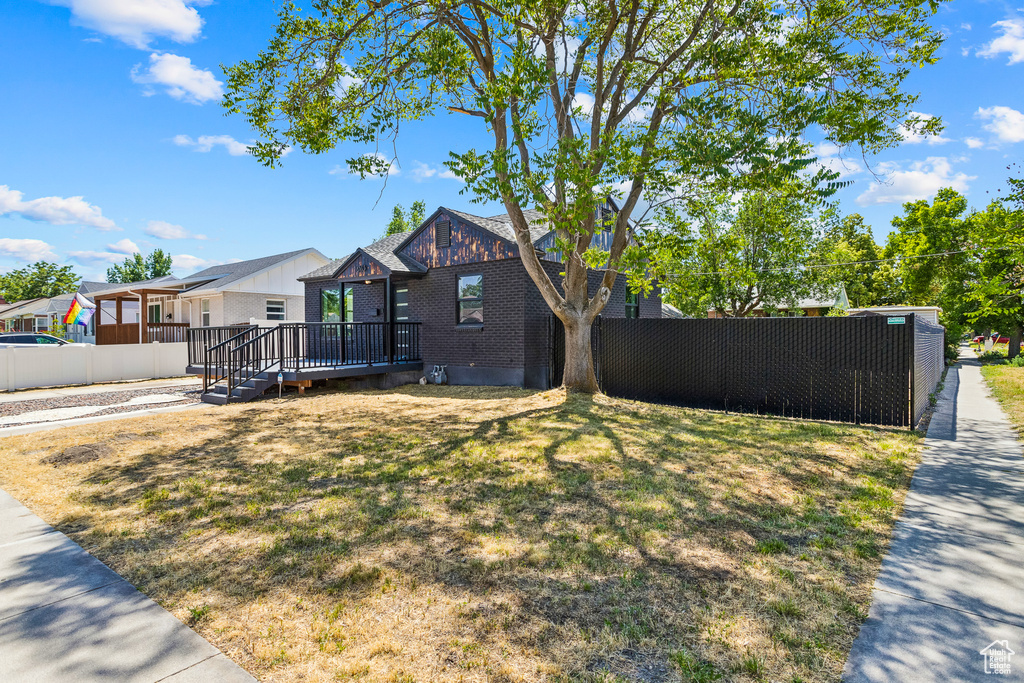 View of front of property with a deck and brick siding