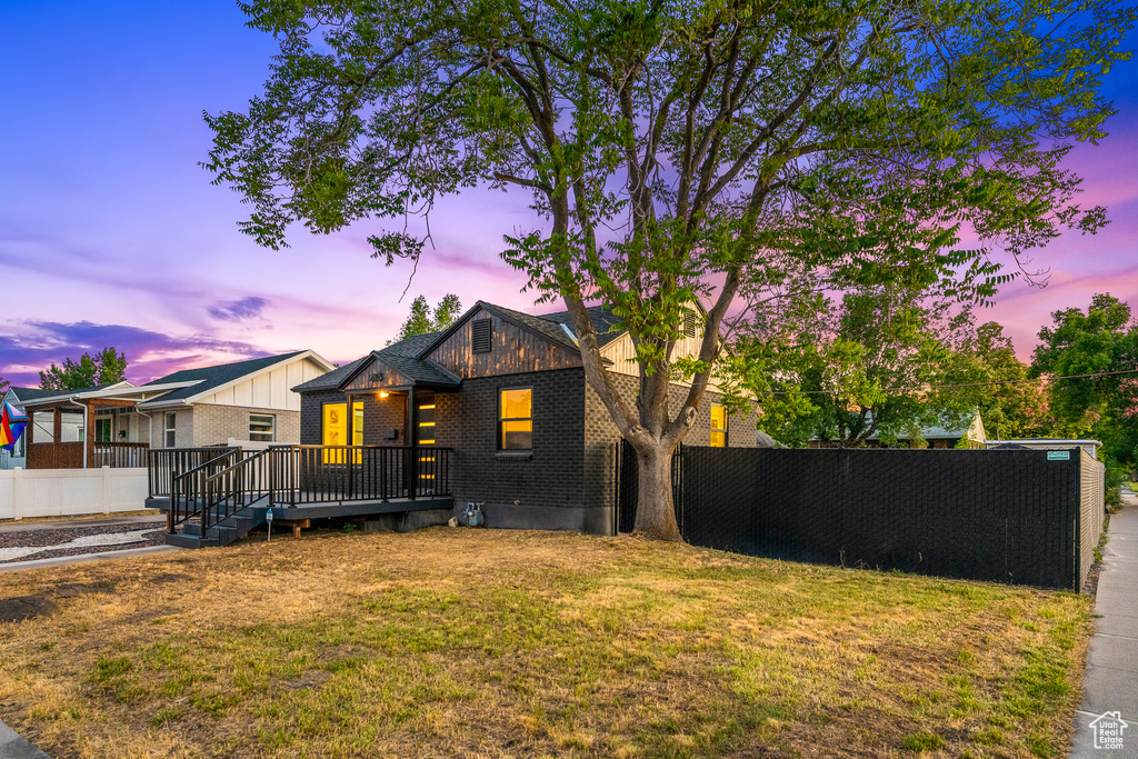 View of front of home with a wooden deck and brick siding