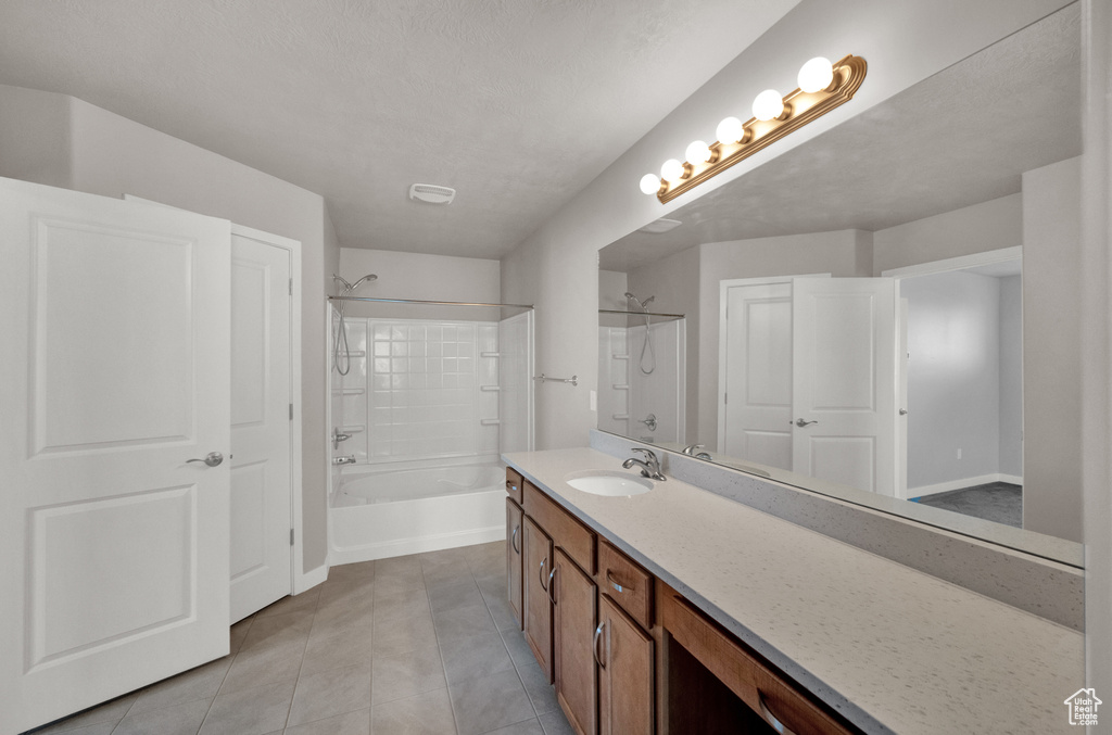 Full bath with vanity, tile patterned flooring, and shower / tub combination