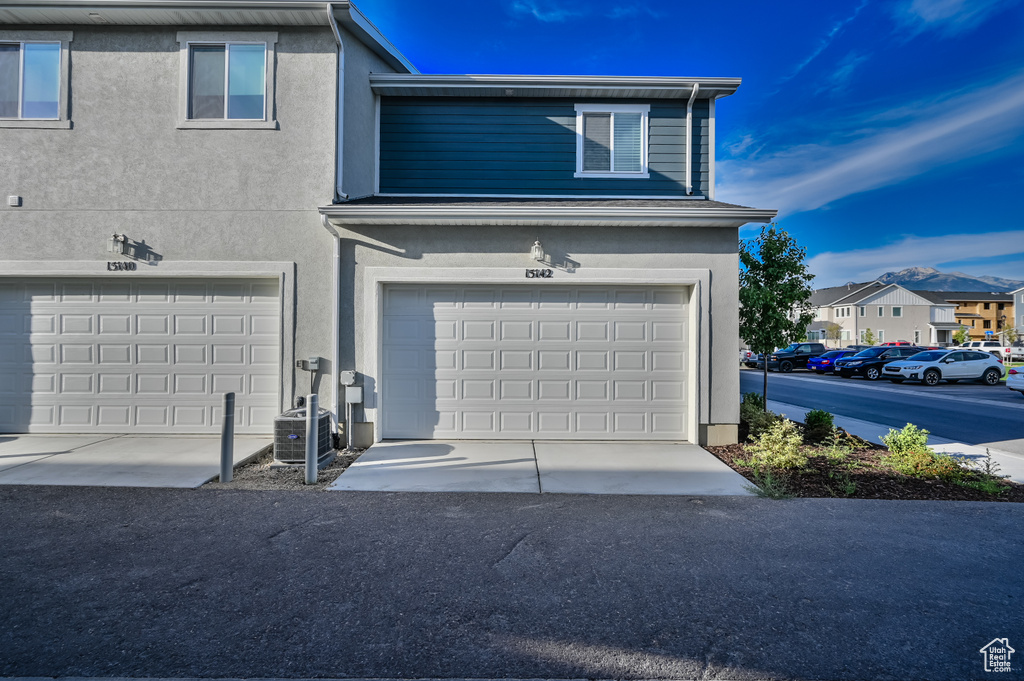 View of front of house with a garage and stucco siding