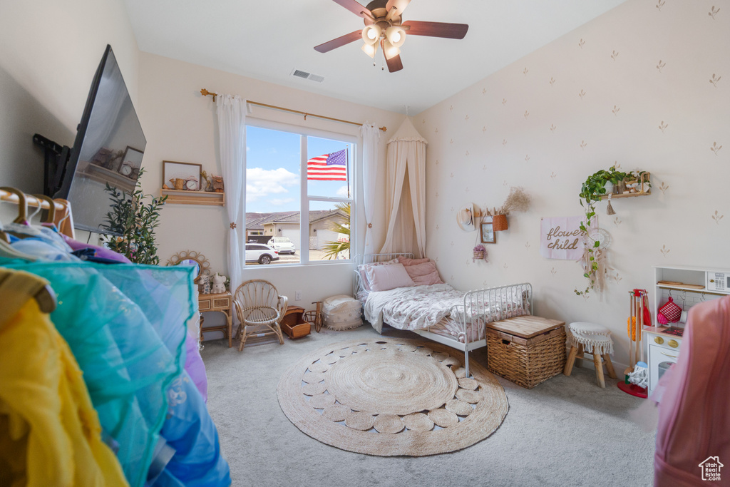 Carpeted bedroom featuring a ceiling fan