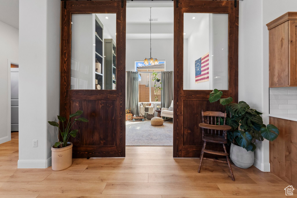 Foyer featuring wood finished floors and a chandelier