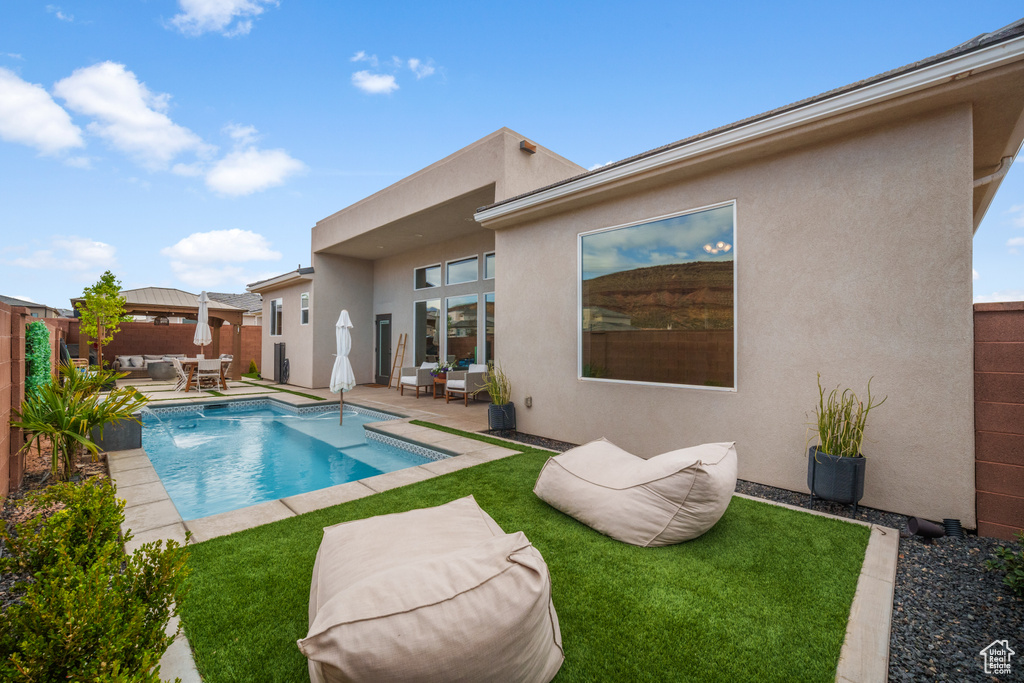 View of pool featuring an outdoor living space, a gazebo, a fenced backyard, and a patio