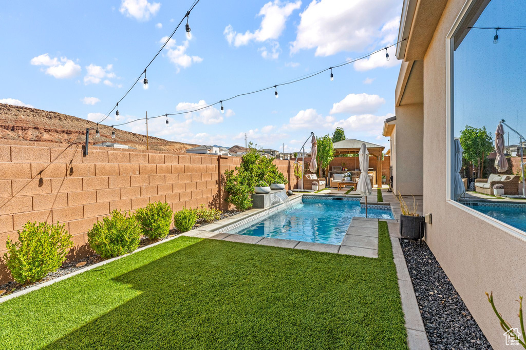 View of pool featuring a fenced backyard, a gazebo, an outdoor hangout area, and a patio area