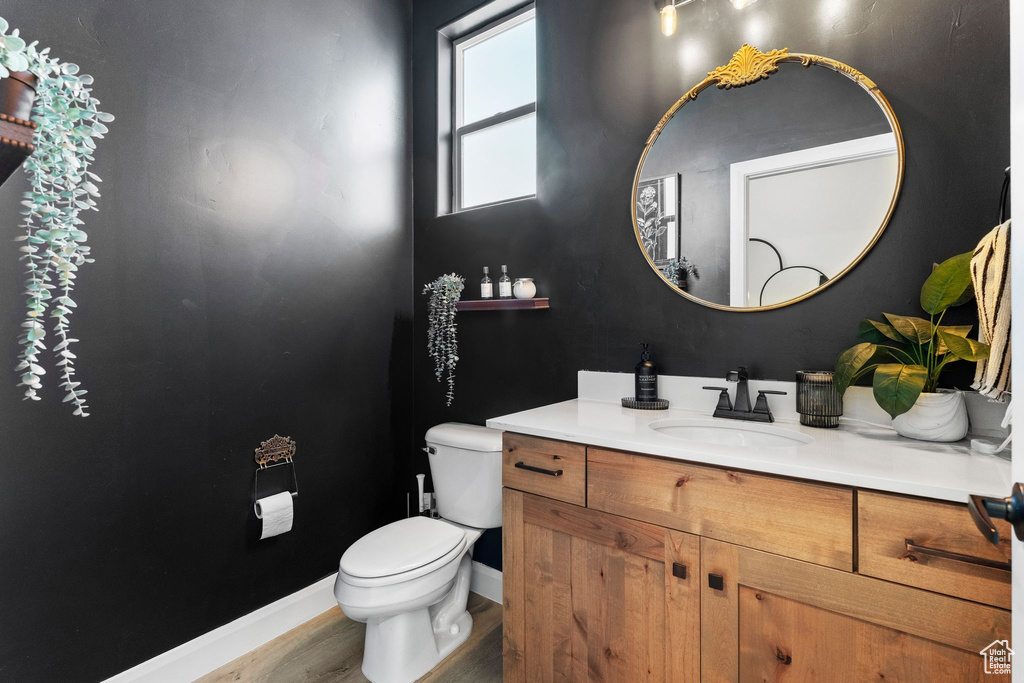 Half bathroom with vanity and wood finished floors