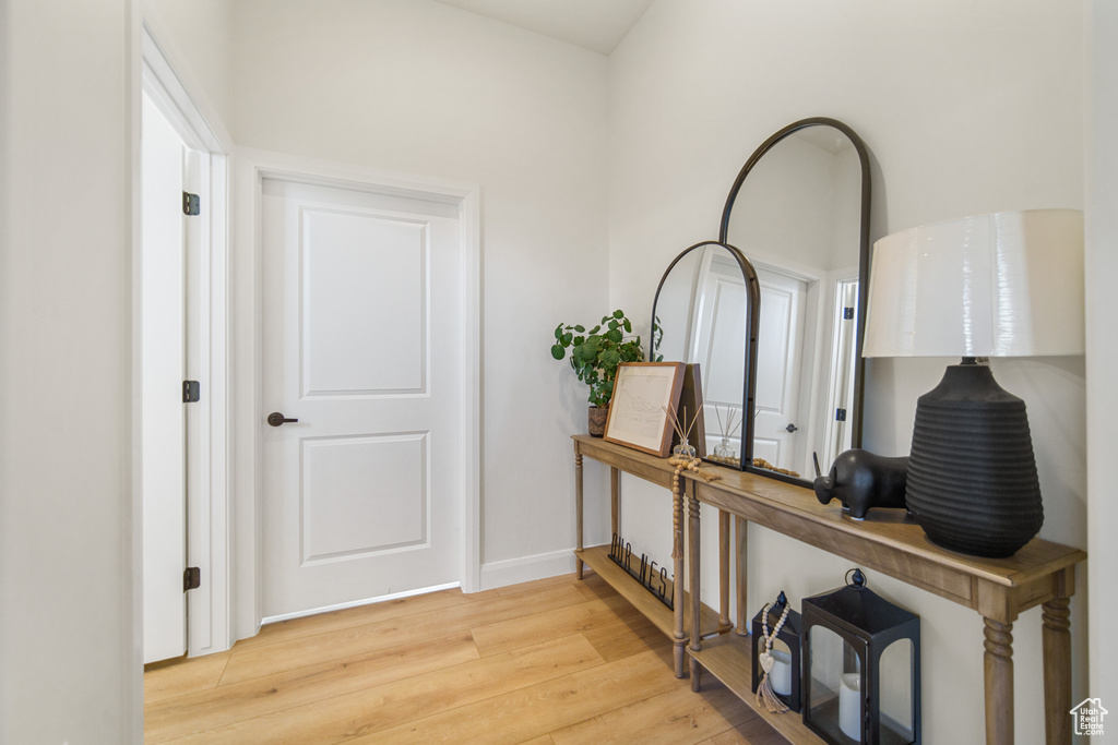 Corridor with light wood-style flooring and baseboards
