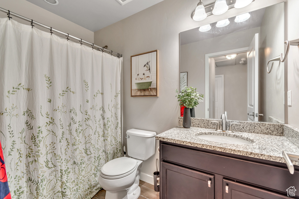 Bathroom with vanity, wood finished floors, and a shower with curtain