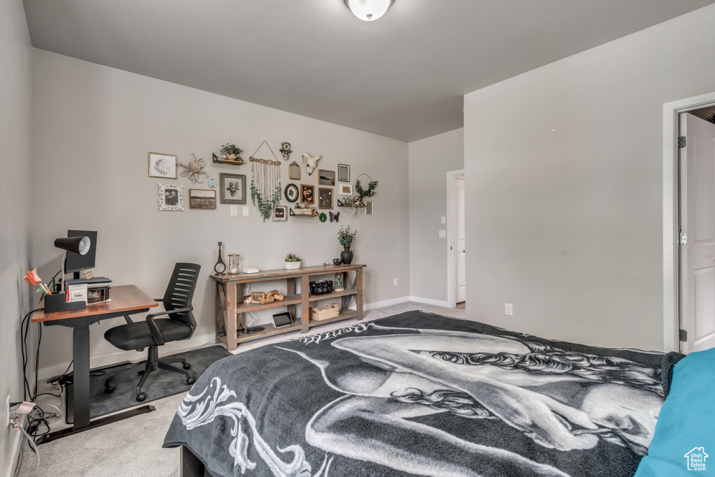 Bedroom with carpet floors and an office area