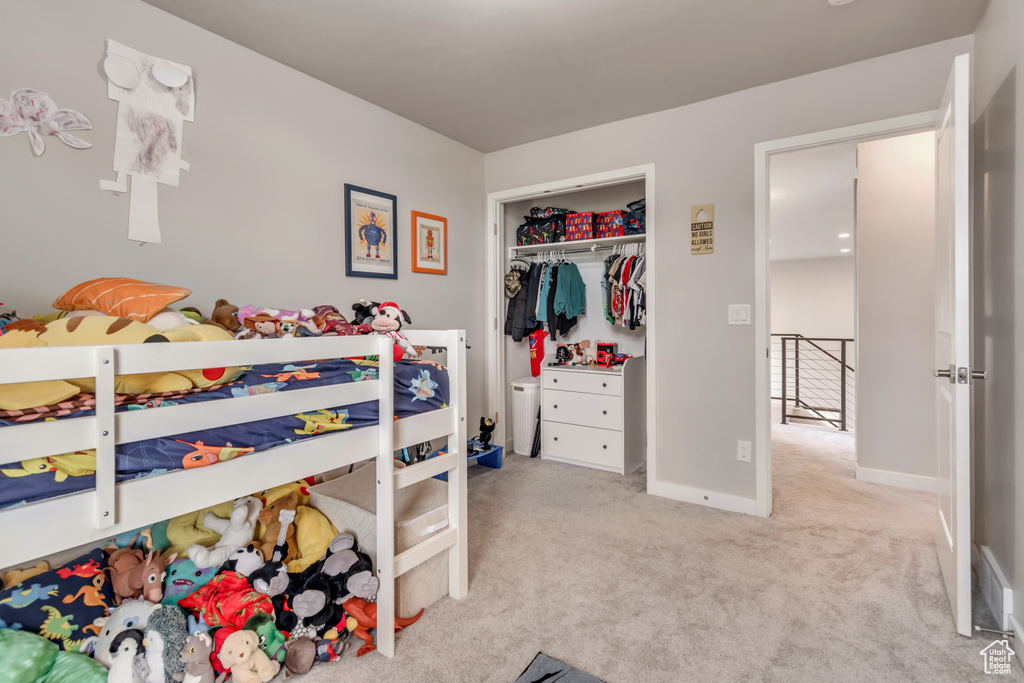 Carpeted bedroom with a closet and baseboards