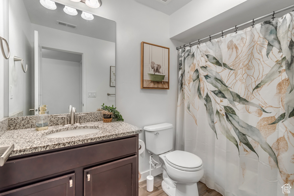 Bathroom featuring vanity, wood finished floors, and a shower with shower curtain