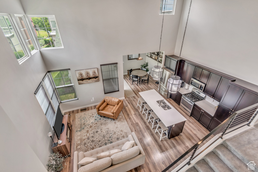 Living area featuring a towering ceiling and light wood-type flooring