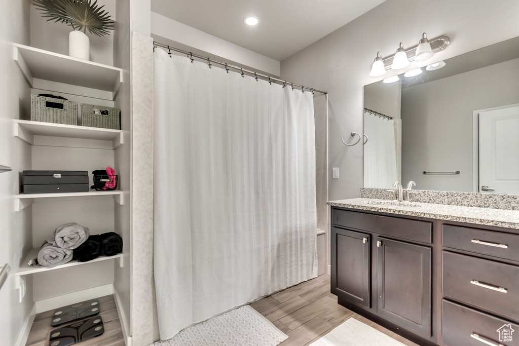 Bathroom with wood finished floors, vanity, a shower with curtain, and recessed lighting