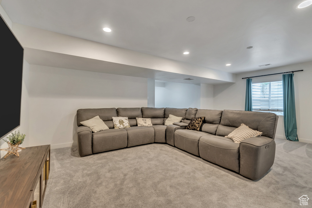 Living area with light colored carpet and recessed lighting