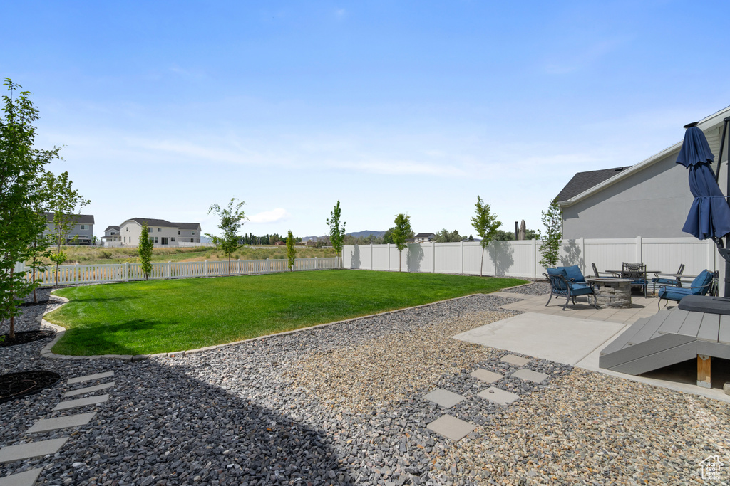 Fenced backyard featuring a patio area and an outdoor fire pit