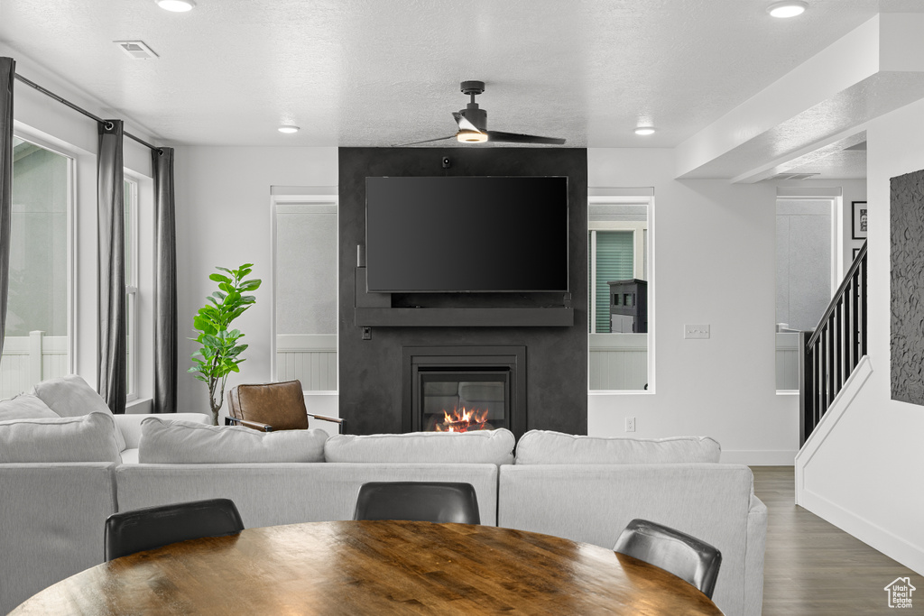 Living area with wood finished floors, a fireplace, stairway, a ceiling fan, and recessed lighting