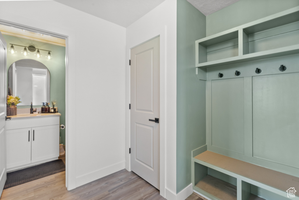 Mudroom featuring light wood-style floors and bar area